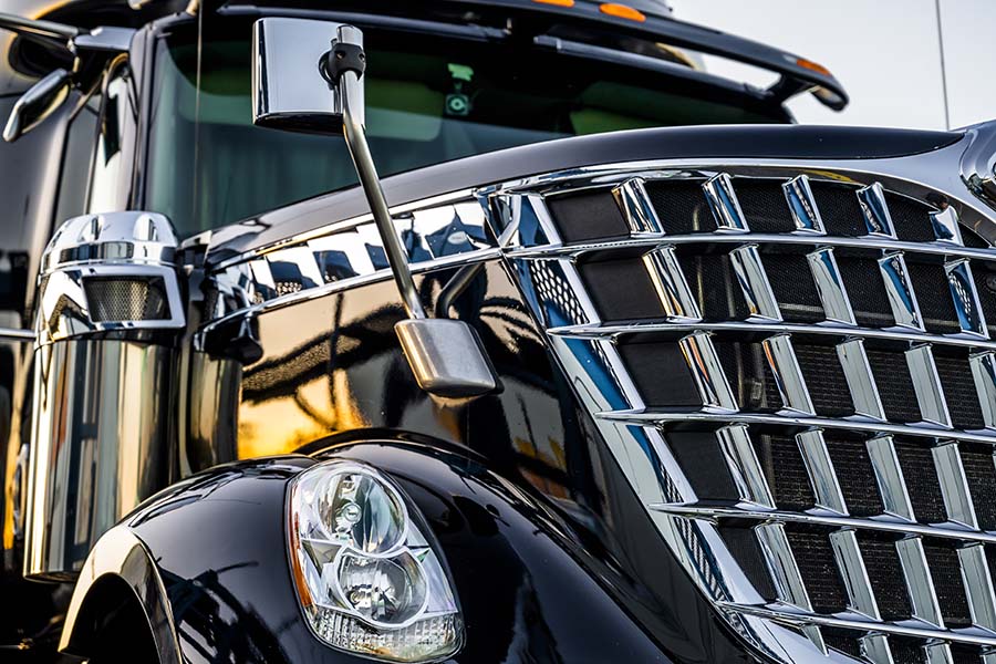 About Our Agency - Closeup View of the Front of a New Modern Black Truck with Shiny Chrome Grille